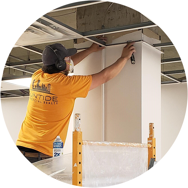 photo of a Suntide construction worker on a ladder, getting ready to add ceiling tiles