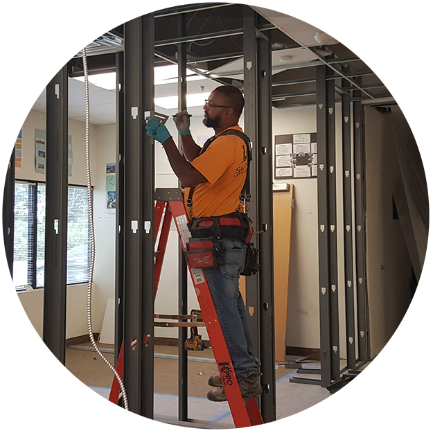 photo of a construction worker doing the initial framing of new office walls